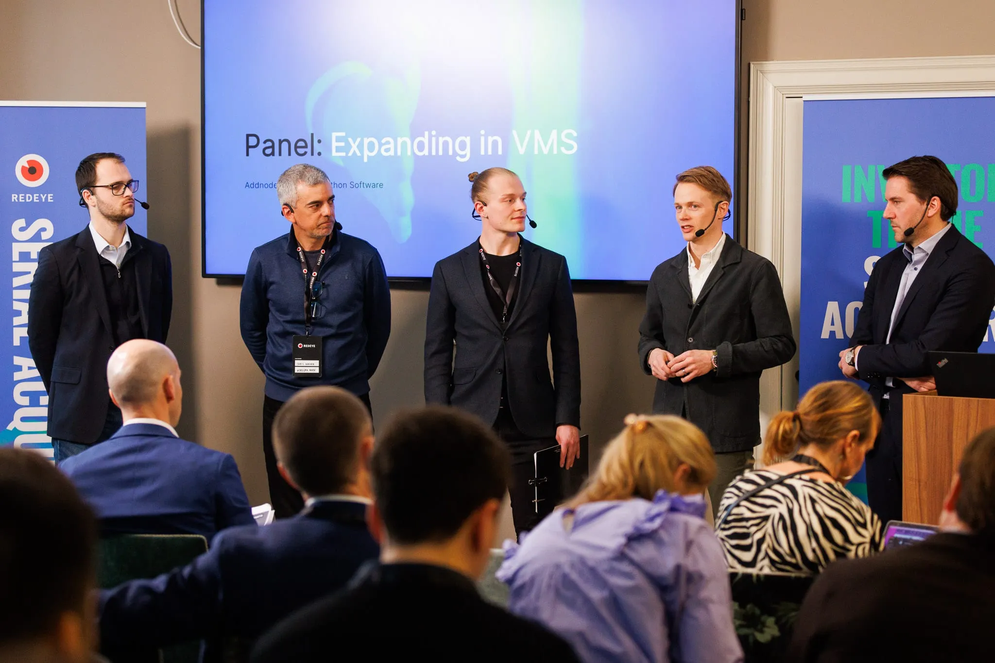 Paneldebatt på scenen under rubriken Expanding in VMS, med publik i förgrunden