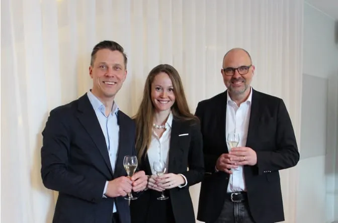 Tre personer höjer sina glas vid starten av partnerskapet
